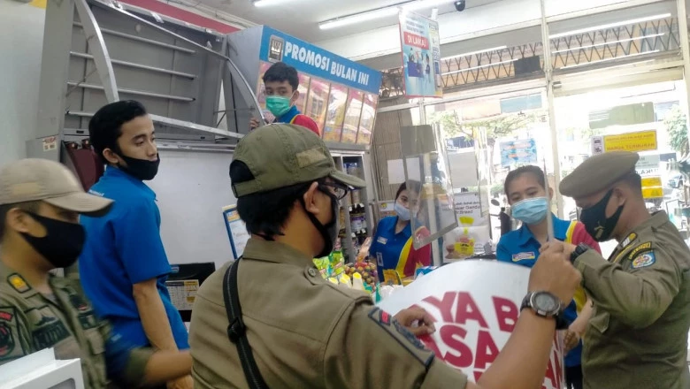 Tegakkan Perda KTR, Satpol PP Ingatkan Pedagang di Beji Tutup Rokok Pakai Tirai