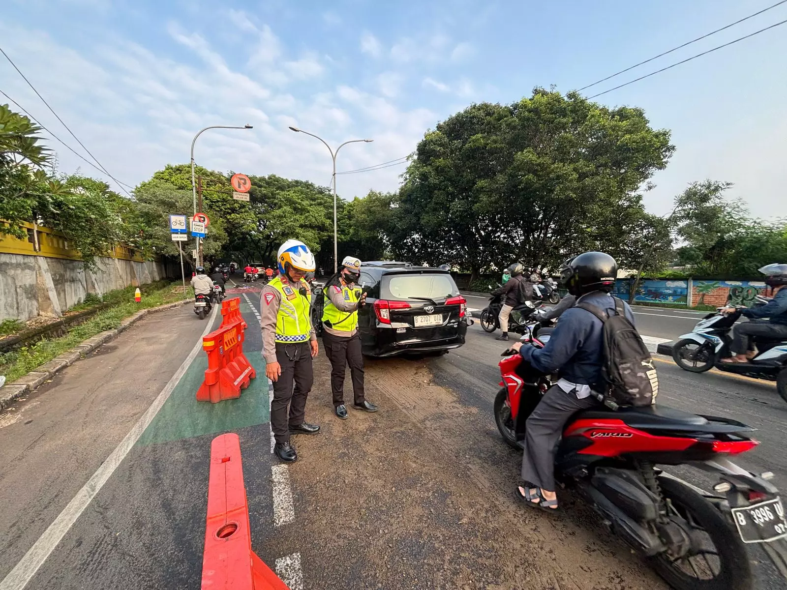 Bahayakan Pengguna Jalan, Sat Lantas Polres Metro Depok Bersihkan Tumpahan Oli di Jalan Juanda